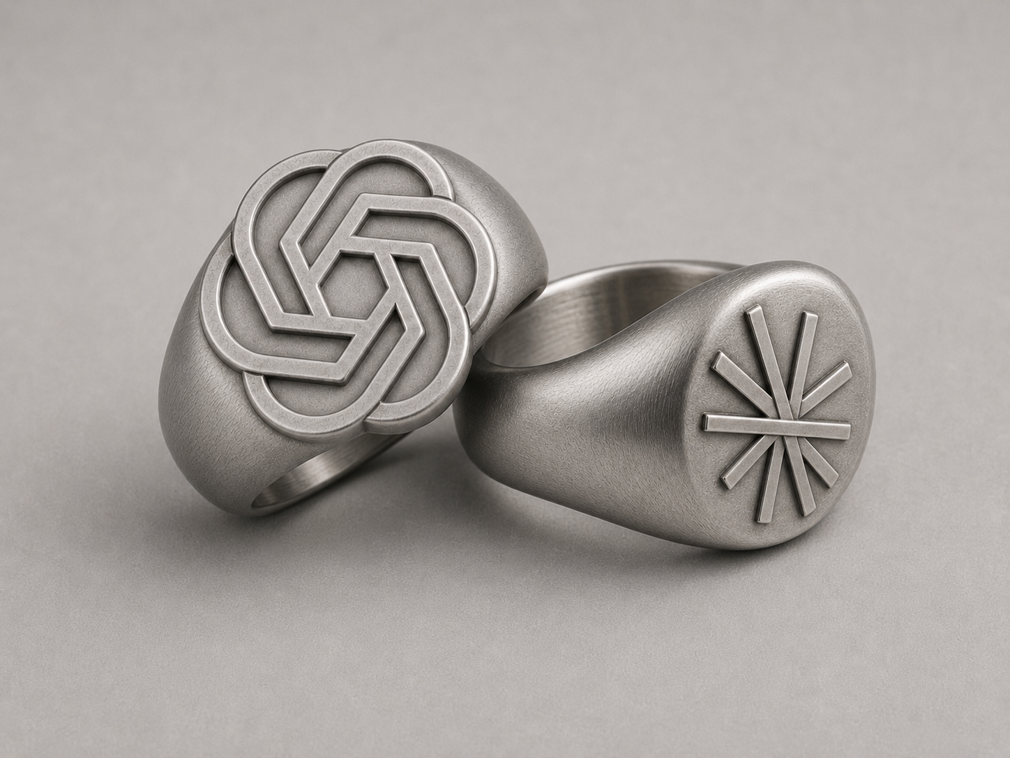 Two silver signet rings engraved with abstract AI symbols